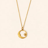 Moon & Star shell pendant necklace with gold-tone crescent moon and star design and natural shell inlay on a warm ivory backdrop