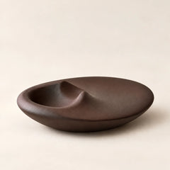 Empty matte brown concrete Palo Santo holder showing its rounded dish and recessed resting area