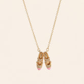 pink ballet shoes necklace in a jewelry box with gold chain and sparkling details