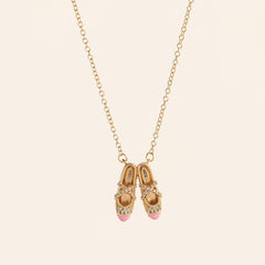 pink ballet shoes necklace in a jewelry box with gold chain and sparkling details