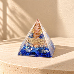 Angled view of a rose quartz and lapis lazuli orgonite pyramid with opal, copper and blue resin details