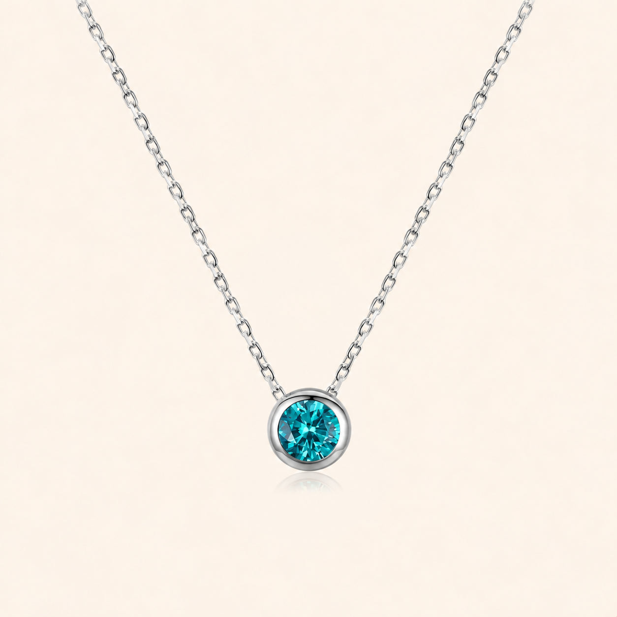 Front view of blue zircon necklace in 925 sterling silver, featuring a faceted blue-green round stone in a polished bezel setting on a delicate silver chain