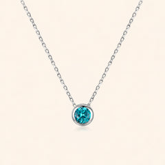 Front view of blue zircon necklace in 925 sterling silver, featuring a faceted blue-green round stone in a polished bezel setting on a delicate silver chain