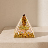 Tiger’s eye and citrine orgonite pyramid, crystal decor on a soft beige background