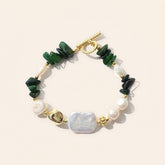 handmade green jade and baroque pearl bracelet with gold accents displayed on a light beige background.