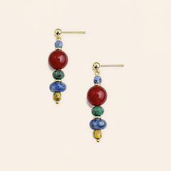 red agate and sodalite handmade earrings with copper ear pins on a light beige background.