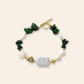 Green jade and freshwater pearl bracelet with gold-plated accents on a cream background
