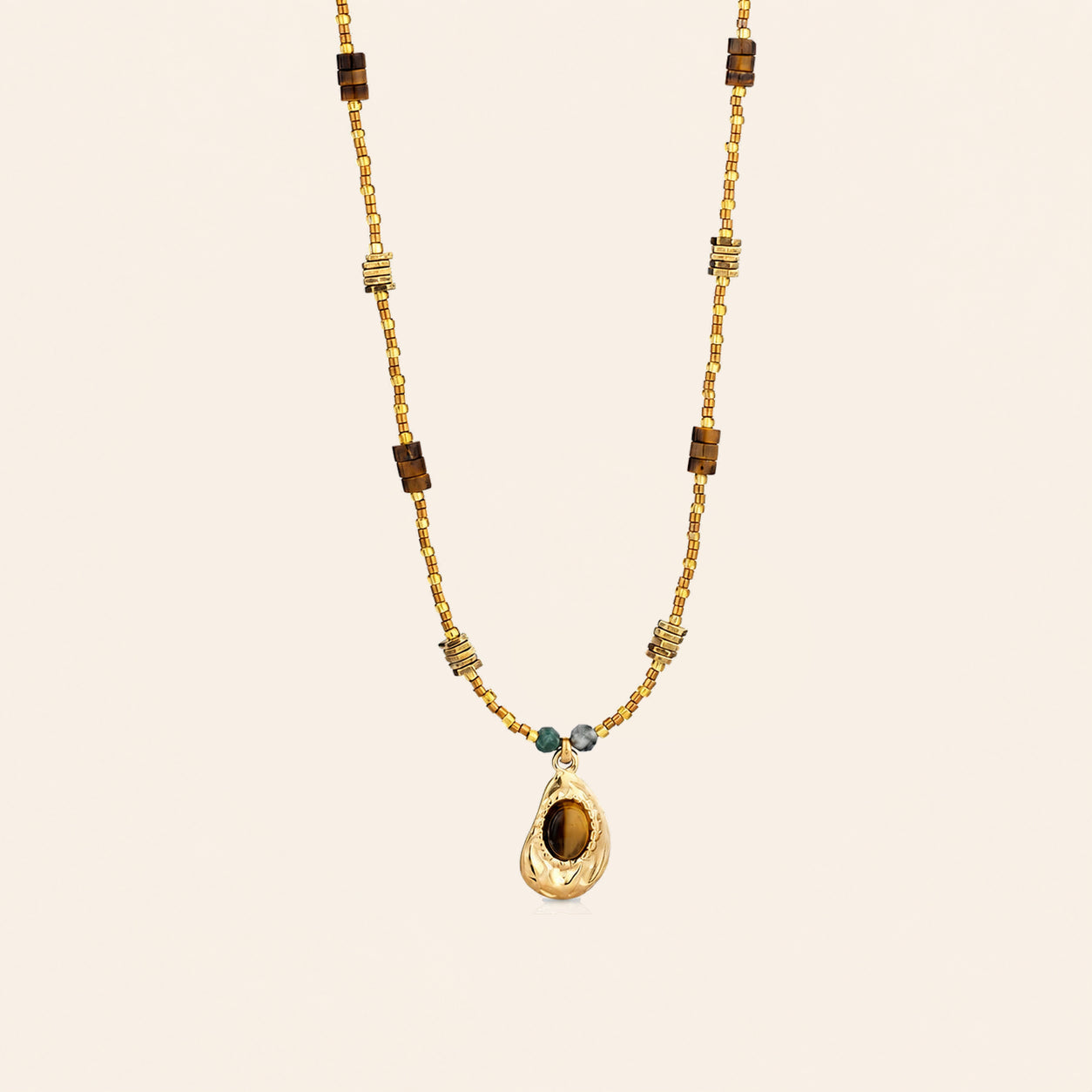 Tiger’s Eye pendant necklace with 18K gold-plated beaded chain and teal stone accents on a cream background