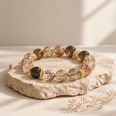 Natural stone bracelet combining smoky quartz and black gold rutilated quartz with delicate gold-tone accents