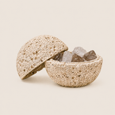 Beige volcanic-texture crystal cleansing bowl with lid holding clear and smoky quartz