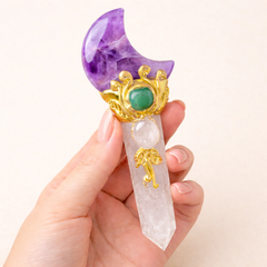 Hand holding a crystal wand with Moon-shaped crystal point with amethyst and clear quartz symbolizing calm, intuition and emotional balance