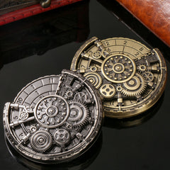 Two mechanical pocket watches, one silver and one gold, on a reflective surface.