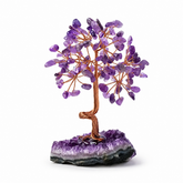 Amethyst feng shui crystal tree with polished purple gemstone leaves on a natural amethyst cluster base with a white background