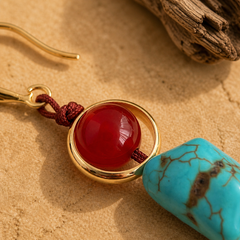 close up of red agate and turquoise handmade earrings with gold tone accents and copper hook