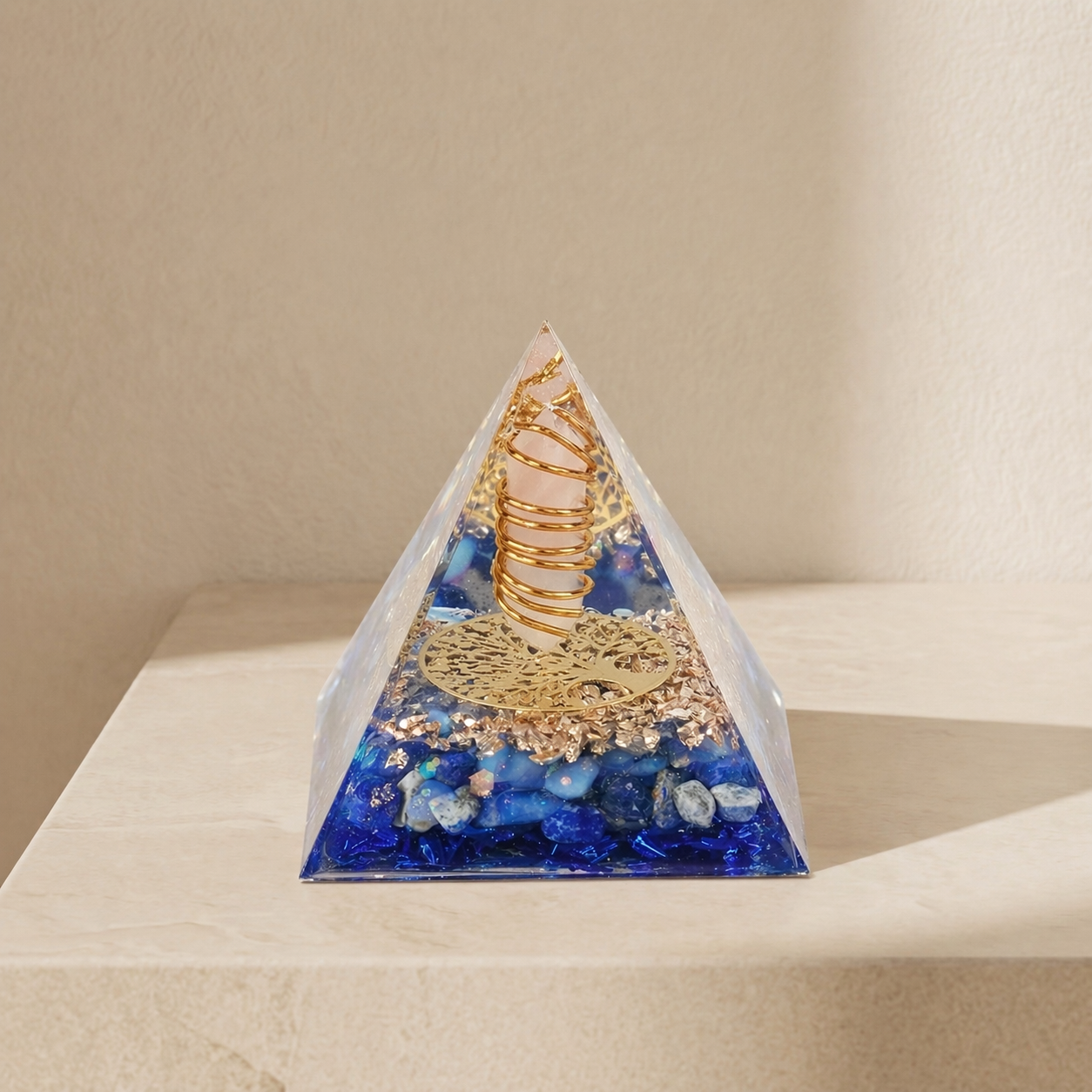 Orgonite pyramid with rose quartz point, blue lapis lazuli stones, copper coil and gold details for emotional healing and inner peace