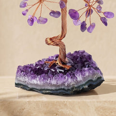 Close-up of an amethyst and chakra feng shui crystal tree with natural purple crystal cluster base
