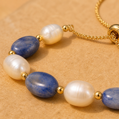 Close-up of a blue aventurine and freshwater pearl bracelet with gold bead accents