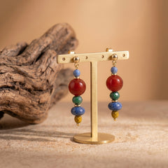 red agate and sodalite handmade earrings displayed on gold stand for courage and clarity jewelry
