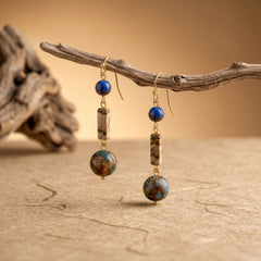 lapis lazuli handmade earrings hanging on driftwood for wisdom intuition and spiritual clarity