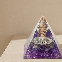 Close-up of an intuition and inner guidance orgonite pyramid with amethyst chips, clear quartz point and copper coil details