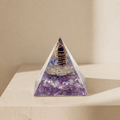 Family harmony orgonite pyramid with amethyst point, lavender fragments, copper coil and silver totem on a neutral background