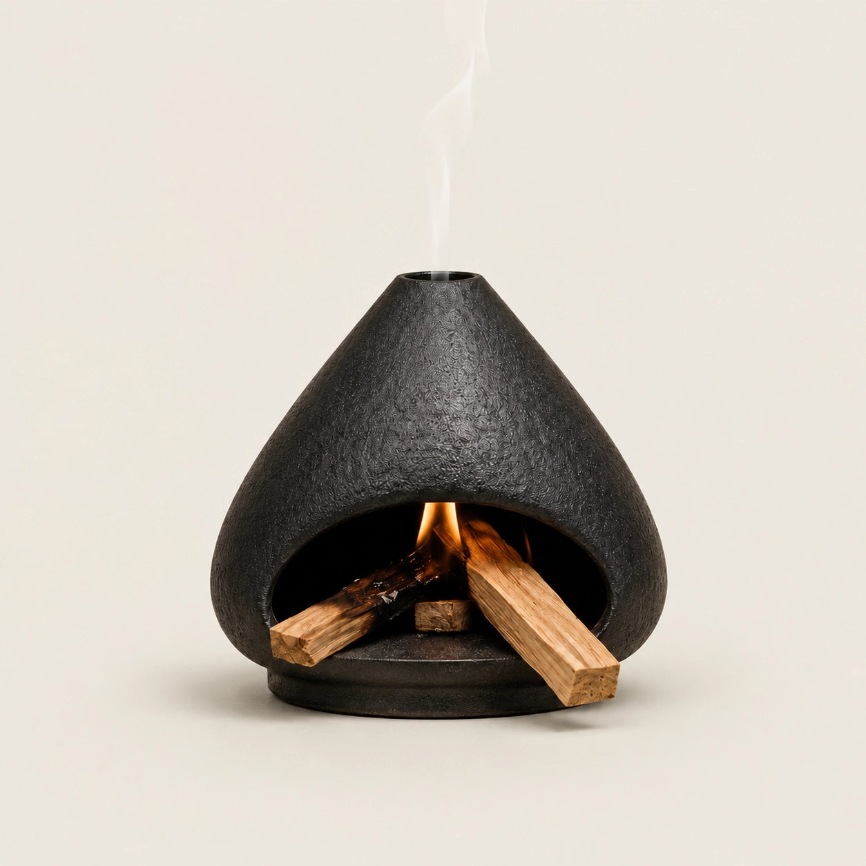 Black ceramic Palo Santo and sage burner with open hearth shape, burning wood, and smoke vent for indoor smudging rituals.