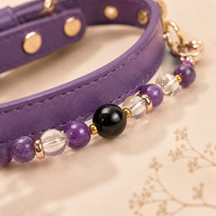 Close-up of amethyst, clear quartz and black obsidian beads on a purple dog collar