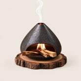 Fired Earth Brown ceramic Palo Santo and sage burner with burning wood and smoke on a natural wood slice