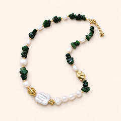 Green jade and freshwater pearl necklace with gold-plated accents arranged on a cream background