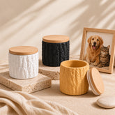 Three textured cement keepsake pet urns with bamboo lids on a stone pedestal beside a memorial photo frame