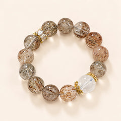 Black Golden Super Seven bracelet with translucent golden-brown beads, a clear quartz centerpiece and gold-plated accents.