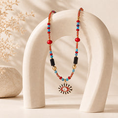 Colorful Evil Eye gemstone necklace draped over a sculptural cream jewelry stand