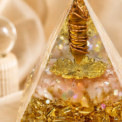 Close-up of abundance and wealth manifestation orgonite pyramid with tiger’s eye point, citrine chips, copper coil, and gold foil details
