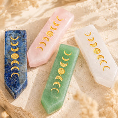 Close up of moon phase crystal wands with gold lunar symbols for mindfulness, reflection, and emotional balance
