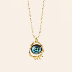 gold evil eye pendant necklace with classic blue eye design on neutral background