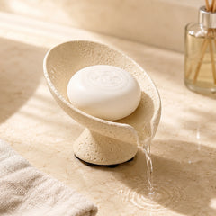 Self draining soap dish with water flowing through the curved drainage design.