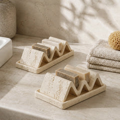 Double-sided natural stone soap dish with beige and white soap holders in spa bathroom