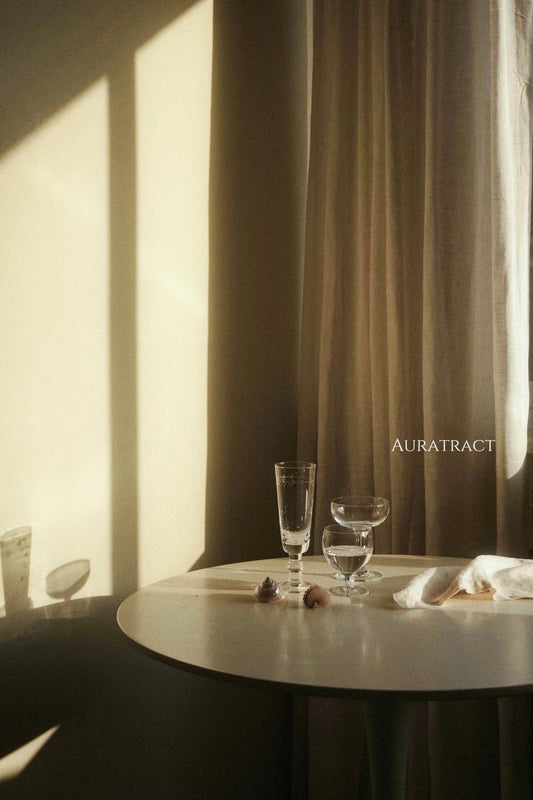 A calm, sunlit interior with a simple table, glassware, and soft natural light, reflecting a gentle and mindful approach to energy healing in everyday life.