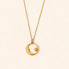 Moon & Star shell pendant necklace with gold-tone crescent moon and star design and natural shell inlay on a warm ivory backdrop