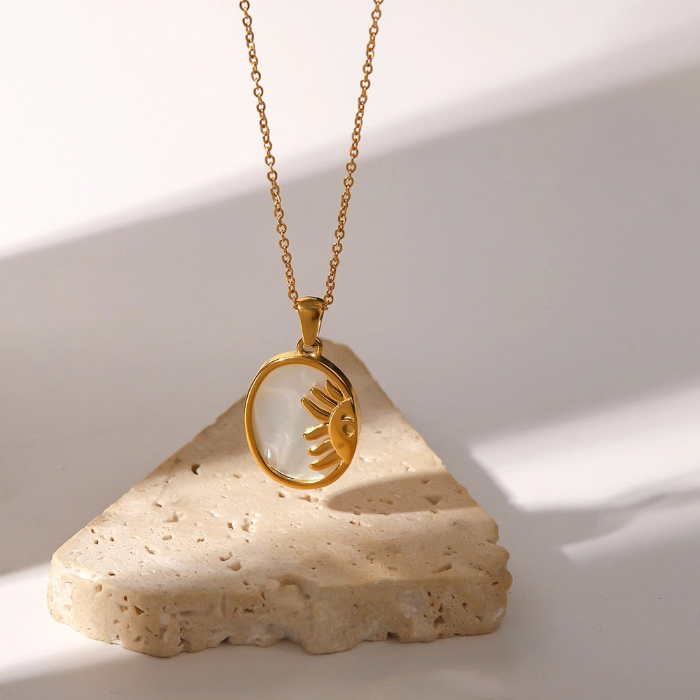Sun and Moon shell pendant necklace displayed on natural stone
