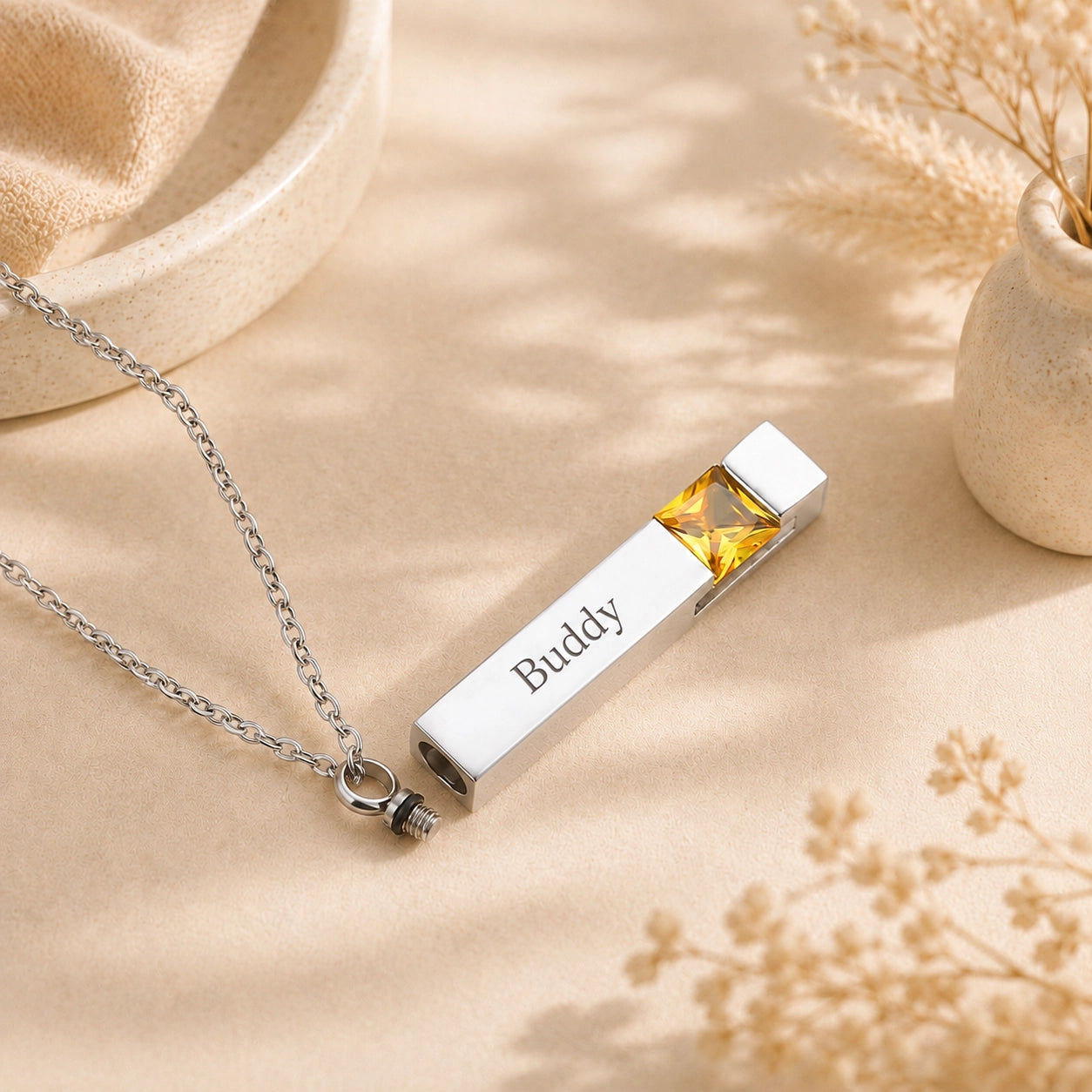 Custom pet name necklace engraved with Buddy, golden birthstone and discreet keepsake compartment