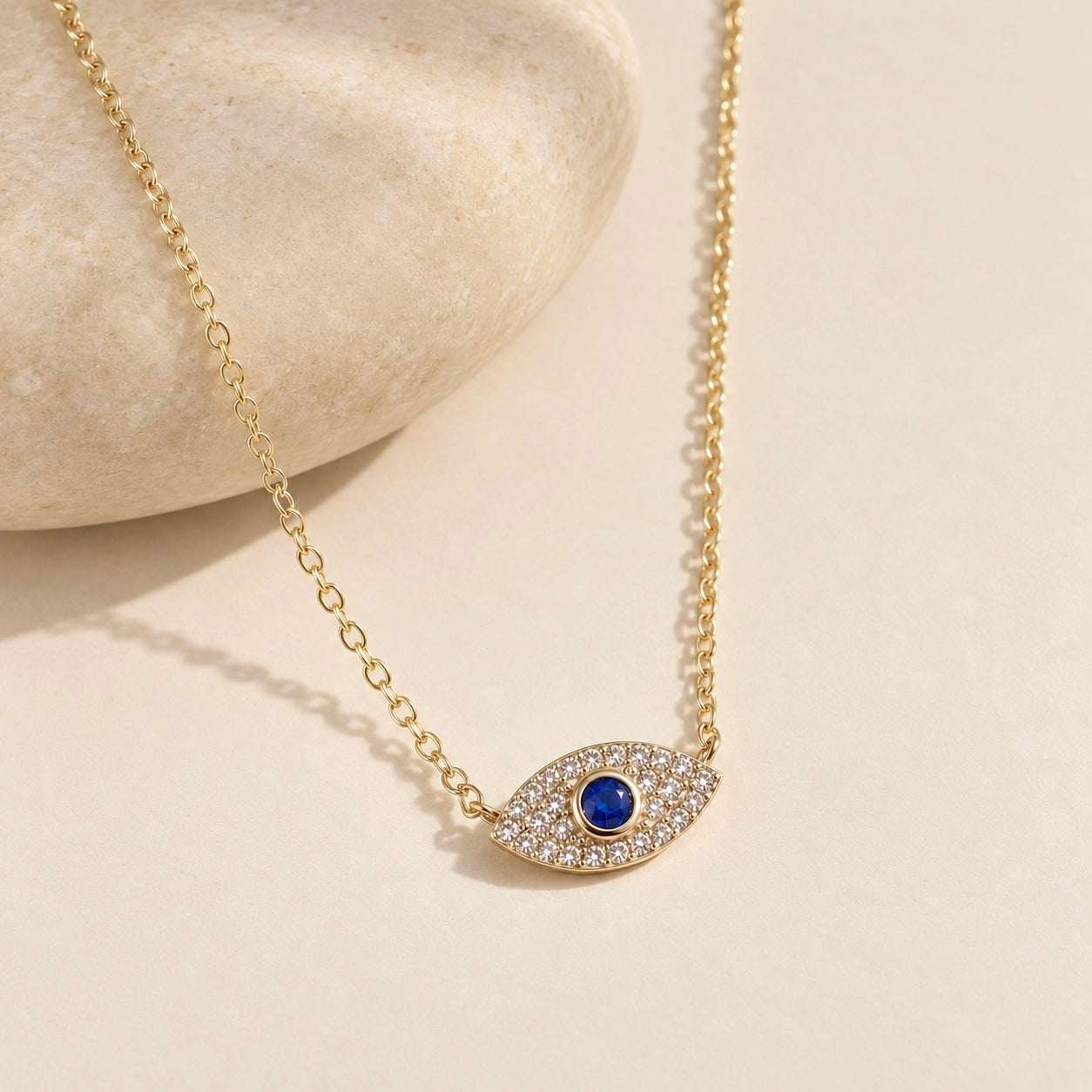 Gold-plated 925 sterling silver evil eye necklace with zircon-set blue eye pendant styled with a smooth warm ivory stone