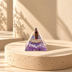 Angled view of an amethyst and dried lilac orgonite pyramid with copper wire and purple resin details