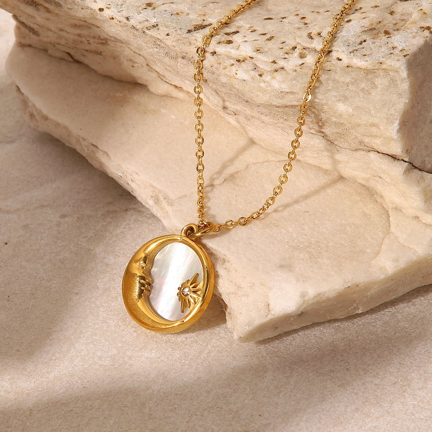 Moon and Star shell necklace with gold-tone crescent pendant in a flat lay