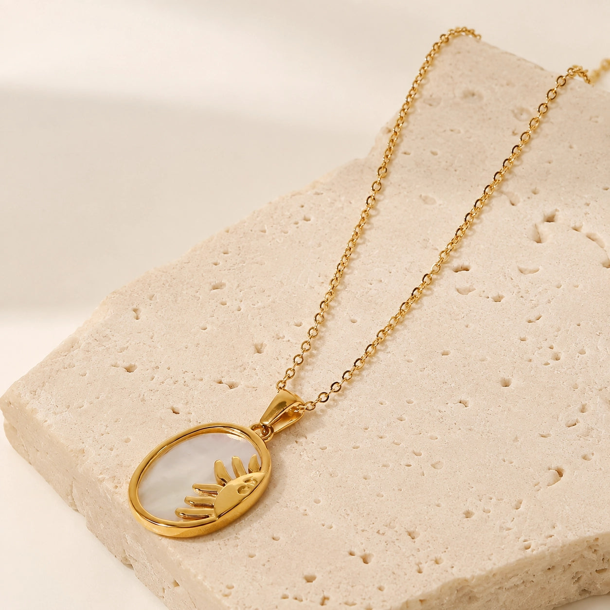 Sun Oval shell necklace displayed on natural stone