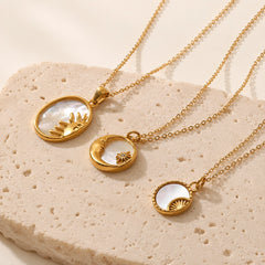 Three celestial shell pendant necklaces arranged in a flat lay