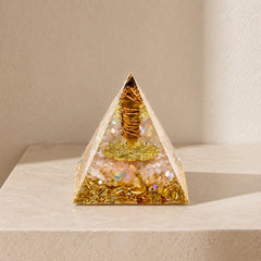 Tiger's Eye and citrine orgonite pyramid on a soft beige background