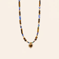 Tiger’s Eye and Sodalite heart necklace with blue and brown natural stone beads on a cream background