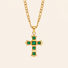 Green Zircon cross necklace with square-cut stones and a gold-tone Figaro chain on a cream background