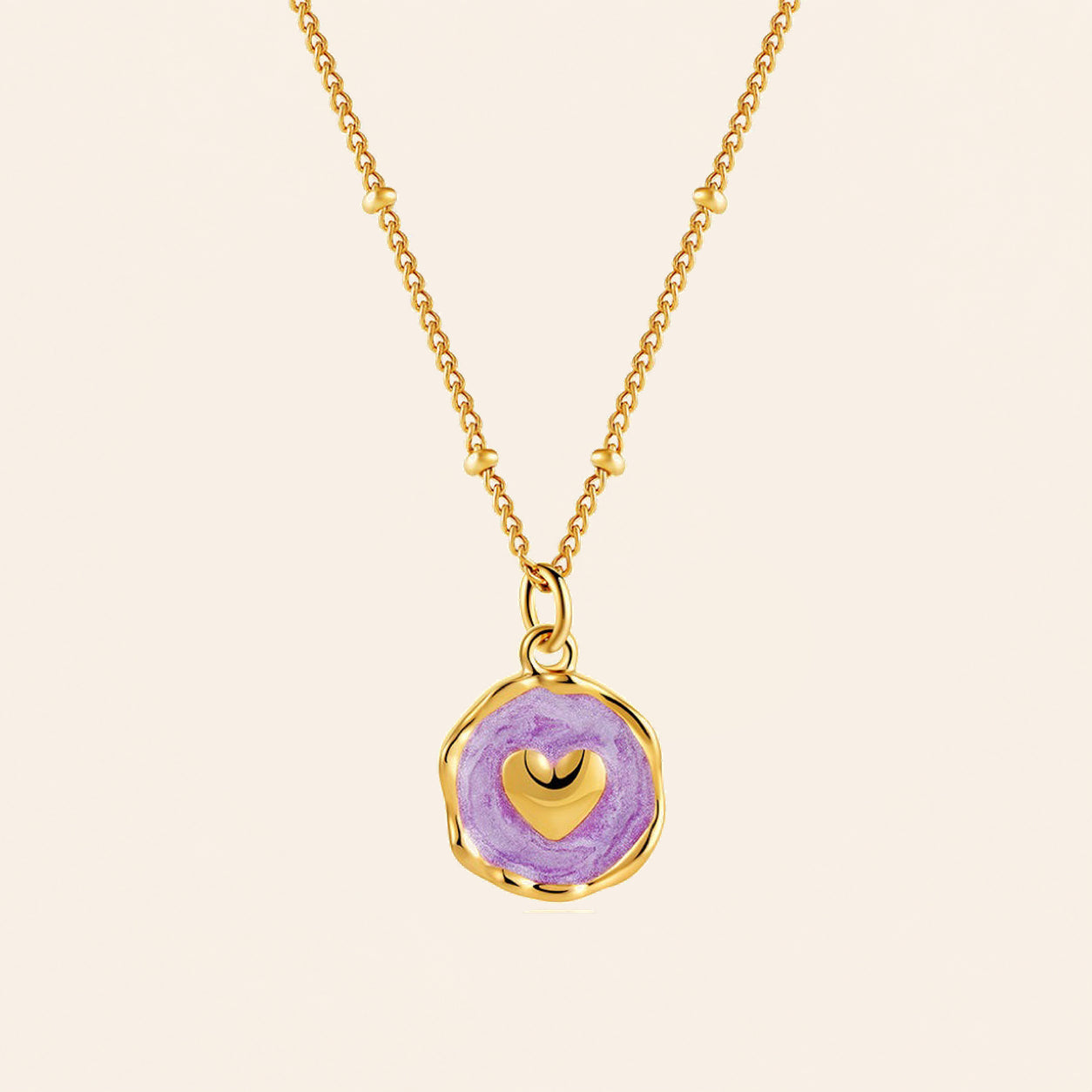Gold-tone necklace with a colorful enamel star pendant on a warm ivory background